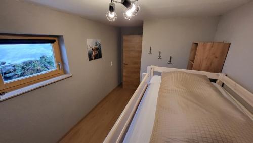 Schlafzimmer mit einem Bett und einem Fenster in der Unterkunft Haus Grübl in Wald im Pinzgau