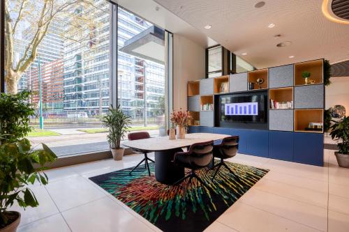 a dining room with a table and a large window at PREMIER SUITES Amsterdam in Amsterdam