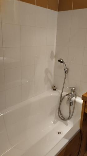 a white bath tub with a shower in a bathroom at Hameau 4 502 - SPA & PISCINE appartement 3 pièces 6 pers in Orelle
