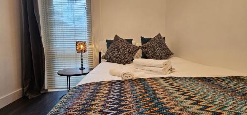 a bedroom with a bed with towels on it at Victorian Superior Property in London