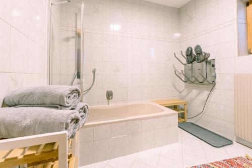 y baño blanco con bañera y ducha. en Landhaus Stieglschuster, 