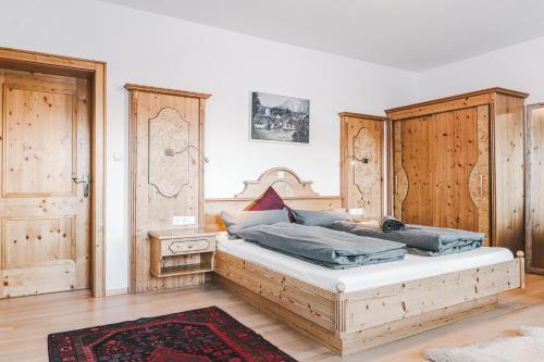 的住宿－Landhaus Stieglschuster，一间卧室配有一张带木制橱柜的大床