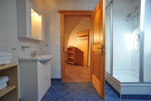 een badkamer met een bad, een wastafel en een douche bij Appartementhaus Bad Salve in Hopfgarten im Brixental