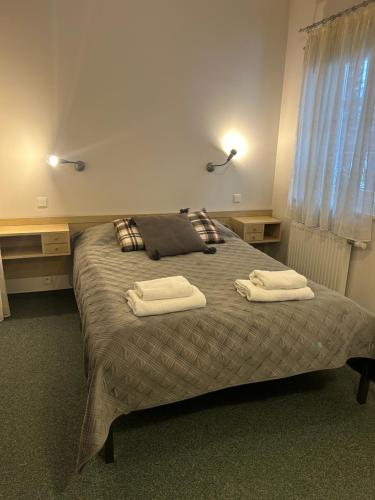 1 dormitorio con 1 cama con 2 toallas en Willa Marysin Bukowina Tatrzańska, en Bukowina Tatrzańska