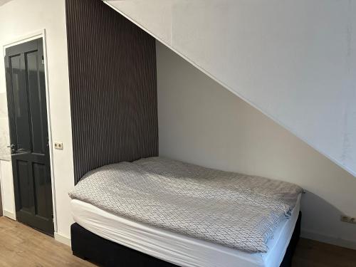 uma cama num quarto debaixo de uma escada em B&B Santorini em Maasbree