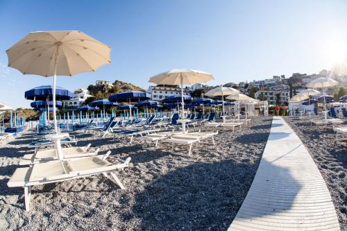 a bunch of chairs and umbrellas on a beach at Grand Hotel De Rose in Scalea
