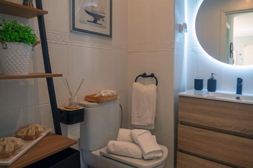 a bathroom with a toilet and a sink and a mirror at Mijas Costa El Faro 2 Apartamento playa in Mijas