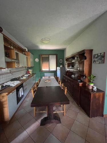 a kitchen with a wooden table in a room at Il giardino di Emilia - Intero appartamento in villa con giardino privato e piscina estiva in Pontirolo Nuovo