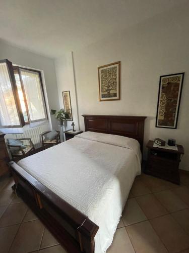 a bedroom with a large bed and two windows at Il giardino di Emilia - Intero appartamento in villa con giardino privato e piscina estiva in Pontirolo Nuovo