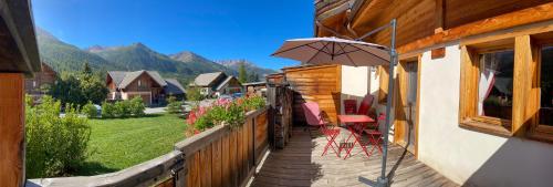 a balcony with a table and an umbrella at Le Longet in Névache