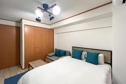 a bedroom with a bed and a ceiling fan at Alita Mansion Kyobashi in Osaka