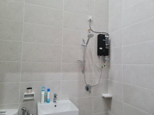 ein Bad mit einer Dusche und einem Waschbecken in der Unterkunft One Sweet Homestay Kulim Hi-Tech utk Msliim shj in Kulim