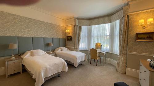 カンタベリーにあるYorke Lodge Bed and Breakfastのベッド2台と窓が備わるホテルルームです。