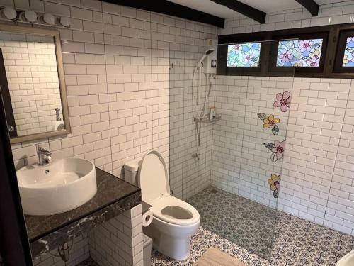 uma casa de banho com um lavatório e um WC em Baan Khun Waew Rimdoi Super Cozy Guesthouse em Chiang Mai