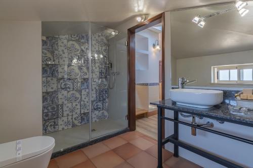 uma casa de banho com um lavatório e um chuveiro em Charming Residence & Guest House Dom Manuel I Adults only em Lagos