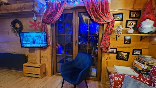 a living room with a blue chair and a television at Hyta na Bani- domek Rabka Zdrój in Skawa