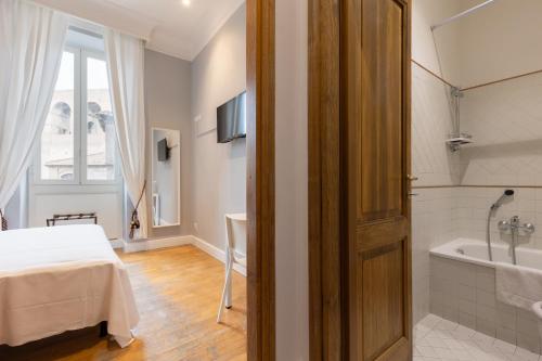a bedroom with a bed and a tub and a sink at River61 - Guest House in Rome