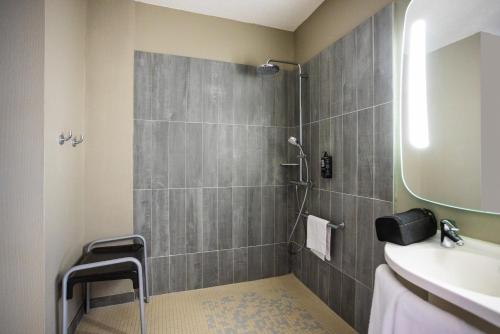 ein Bad mit einer Dusche und einem Waschbecken in der Unterkunft ibis Tarbes Odos in Odos