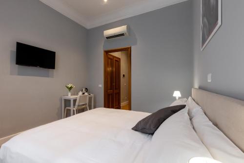 a bedroom with a white bed and a television at River61 - Guest House in Rome
