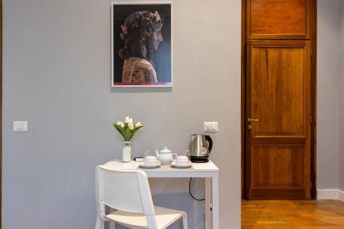 a table with a chair and a vase of flowers at River61 - Guest House in Rome