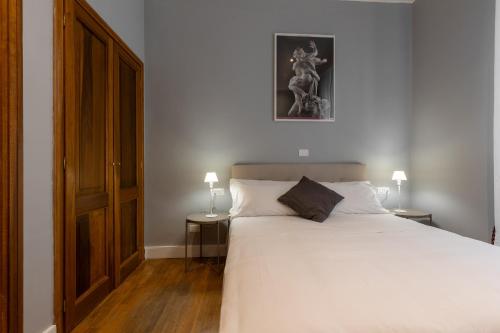 a bedroom with a large white bed and two lamps at River61 - Guest House in Rome