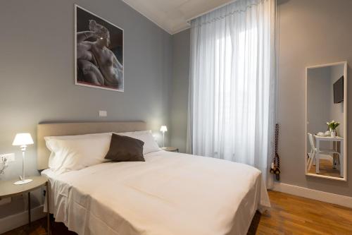 a bedroom with a large white bed and a window at River61 - Guest House in Rome