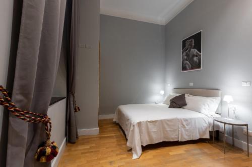 a bedroom with a white bed and a table at River61 - Guest House in Rome