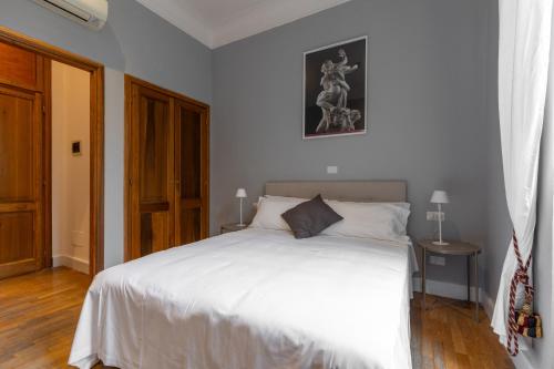 a bedroom with a large white bed and a door at River61 - Guest House in Rome