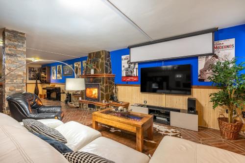 a living room with a couch and a tv at Casa de Amigos La Latina con piscina, chimenea y barbacoa in Illora