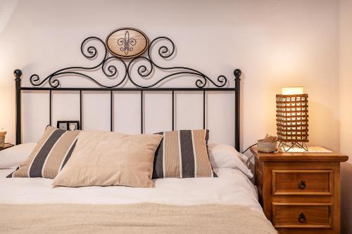 a bedroom with a bed with a clock on the wall at Casa de Amigos La Latina con piscina, chimenea y barbacoa in Illora