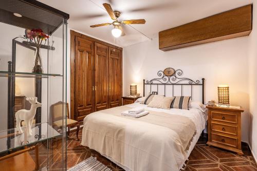 a bedroom with a bed and a ceiling fan at Casa de Amigos La Latina con piscina, chimenea y barbacoa in Illora
