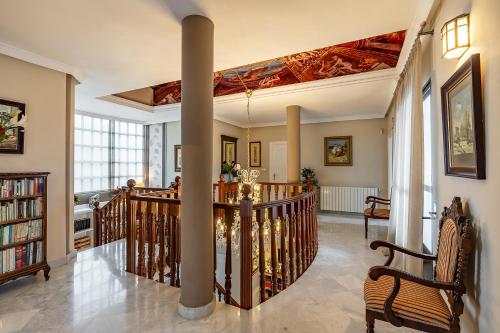 a living room with a staircase with a ceiling at Casa de Amigos La Latina con piscina, chimenea y barbacoa in Illora