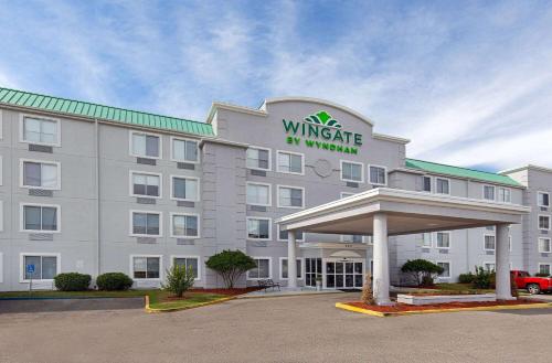 a white hotel with a sign on the front of it at Wingate by Wyndham Hattiesburg in Hattiesburg