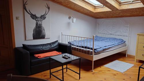 1 dormitorio con cama, sofá y pintura de ciervos en Apartamenty przy STONEHENGE, en Sosnowiec