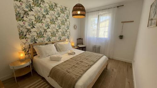 a bedroom with a bed with a floral wall at Le Clos Du Moulin 3 - Maison et Jardin, proche Avignon en Provence in Entraigues-sur-la-Sorgue