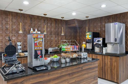 a kitchen with a counter with a refrigerator at Wingate by Wyndham Hattiesburg in Hattiesburg