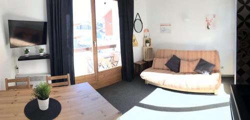 a living room with a couch and a table at Bright studio with balcony in Aime-La Plagne