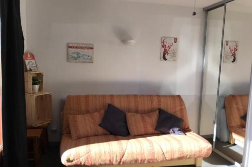 a couch with two pillows in a living room at Bright studio with balcony in Aime-La Plagne