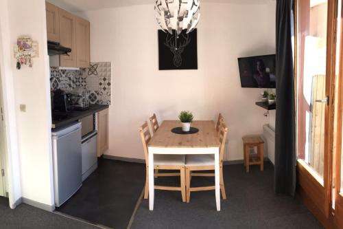 a kitchen with a table and chairs in a room at Bright studio with balcony in Aime-La Plagne