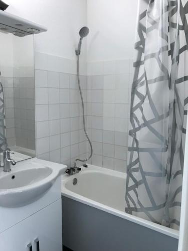 a bathroom with a shower and a sink and a tub at Bright studio with balcony in Aime-La Plagne