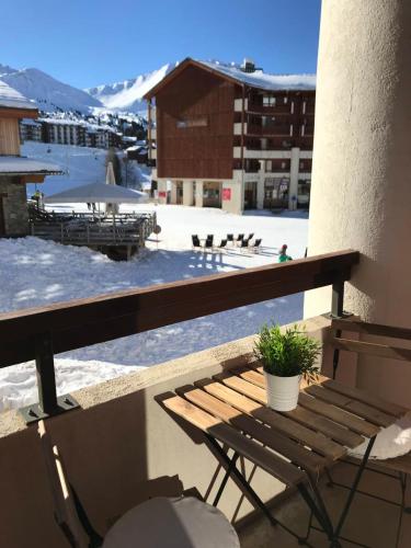 a wooden bench sitting on top of a balcony with snow at Bright studio with balcony in Aime-La Plagne