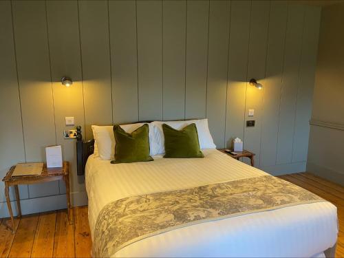 um quarto com uma cama grande e almofadas verdes em Holbrook Manor & Spa - OCEANA COLLECTION em Wincanton