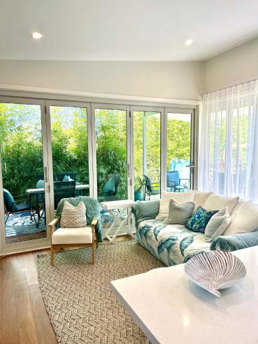 a living room with a couch and a table at Woonona Family Beach Villa 5 min walk to beach in Woonona