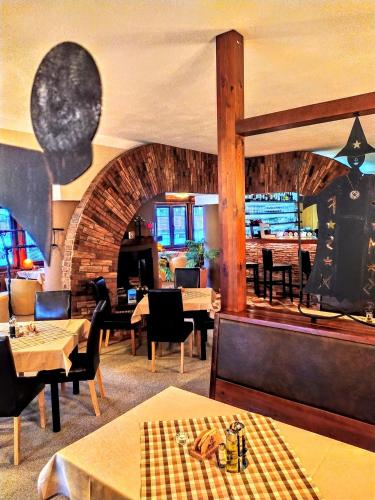 a restaurant with tables and chairs and a fireplace at Penzion Merlin in Frýdlant nad Ostravicí
