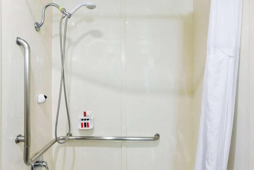 a shower in a bathroom with a shower curtain at Travelodge by Wyndham Commerce Los Angeles Area in Commerce