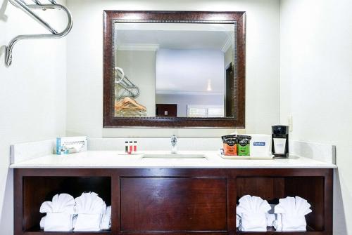 a bathroom with a sink and a mirror at Travelodge by Wyndham Commerce Los Angeles Area in Commerce