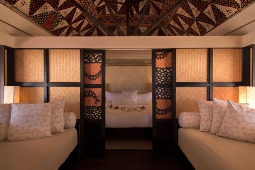 a bedroom with a bed and two windows at Castaway Island, Fiji in Castaway Island