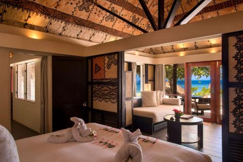 a hotel room with two beds and a patio at Castaway Island, Fiji in Castaway Island