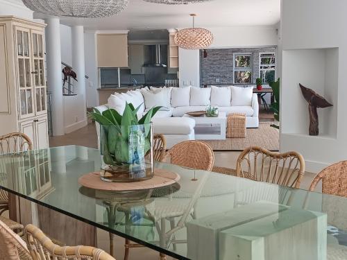 a dining room and living room with a glass table at Haven On Hill in Plettenberg Bay