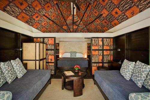 a room with a bed and a couch and a table at Castaway Island, Fiji in Castaway Island